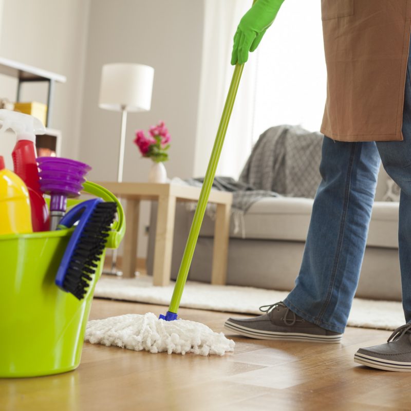 Man holding mop and plastic bucket